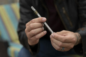 guy holding variable voltage Pyramid vape pen